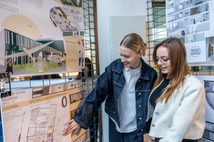 Dwie studentki podczas wystawy prac studenckich, wykonanych w ramach zajęć Projektowanie architektoniczne – usługi II