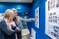 Dwie absolwentki studiów podyplomowych pn. "Architektura Wnętrz i Wystawiennictwa" podczas wystawy wybranych prac projektowych absolwentów tego kierunku.